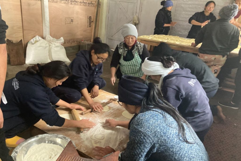 older kids serving in kitchen during losar festival in preparation of the khapse