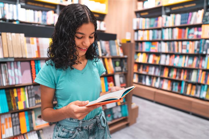 Student reading a book in a library
